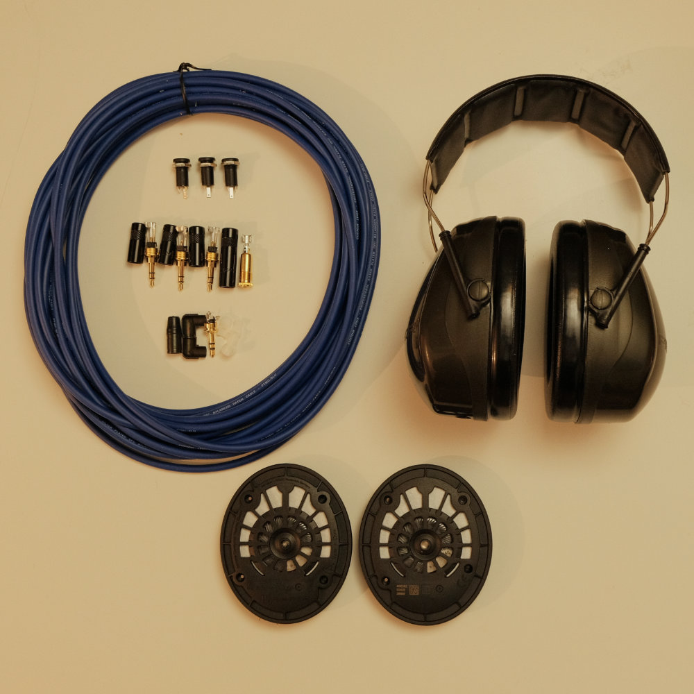 parts laid out on table. includes ear defenders, speakers, cable and connectors